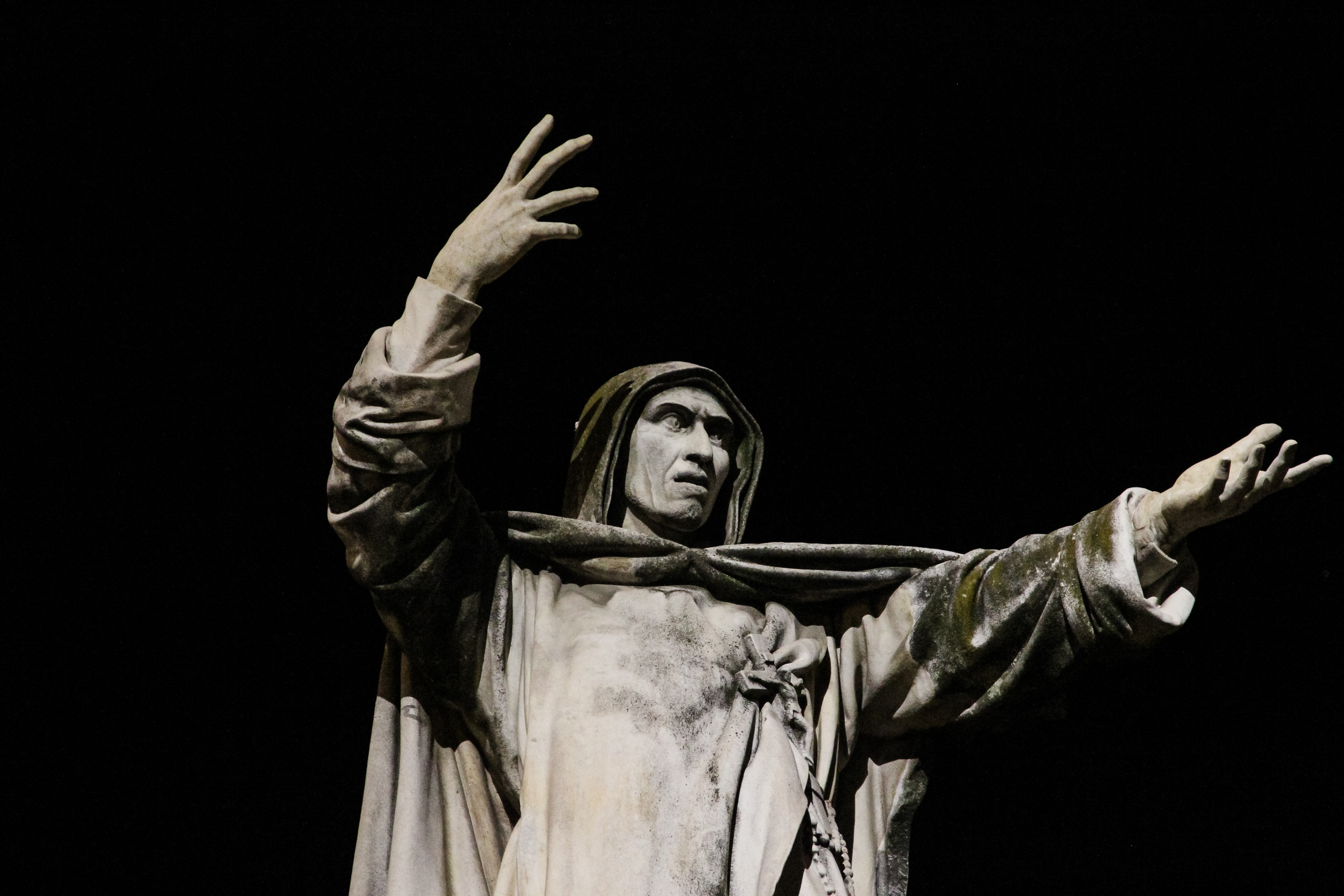 Ferrara bei Nacht: der angestrahlte Savonarola mit ausgebreiteten Armen